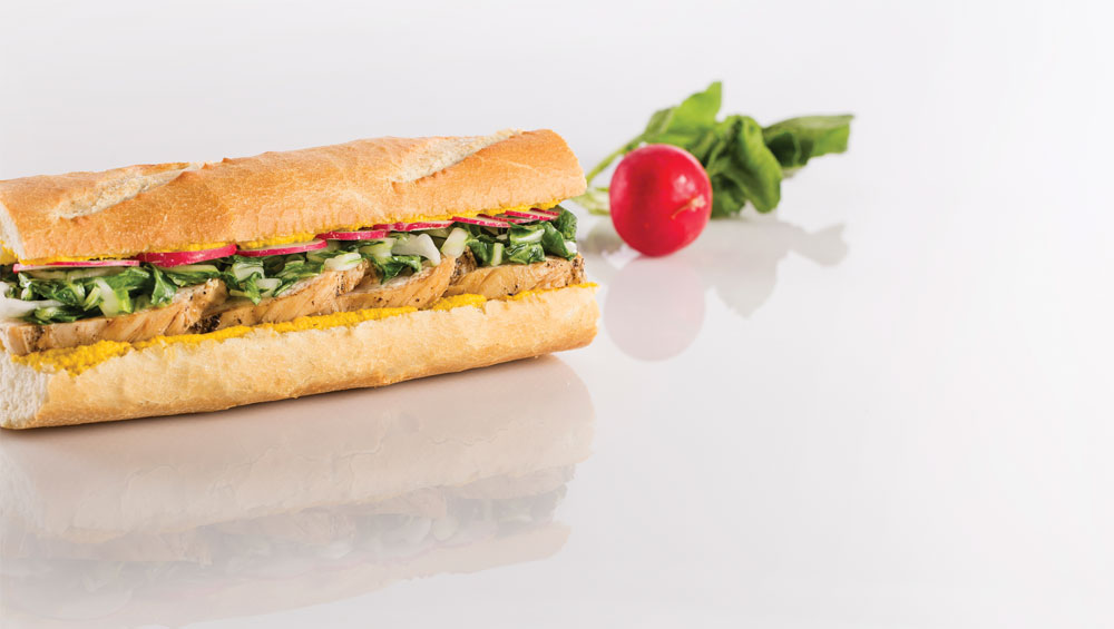 A baguette with chicken, radishes and a ginger carrot spread