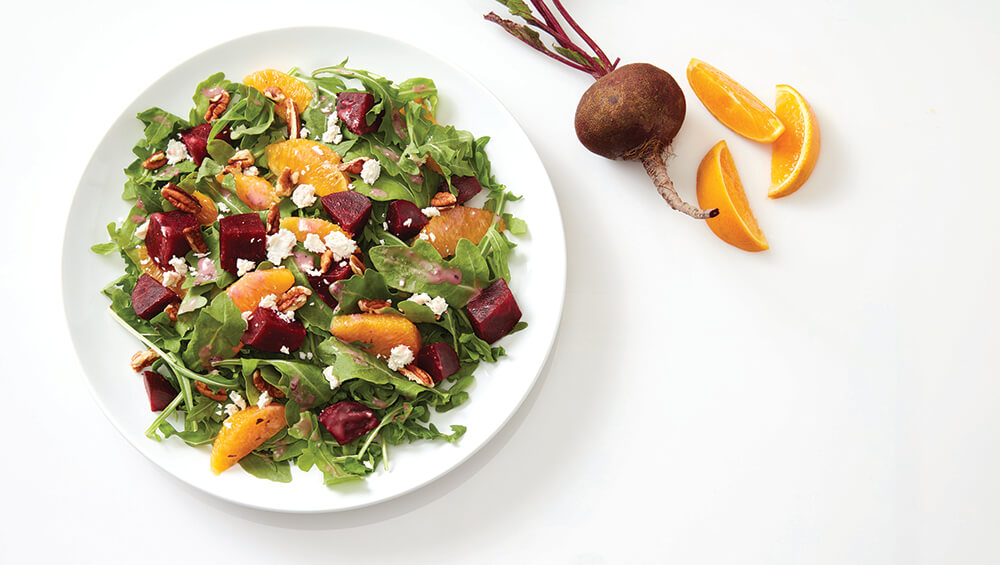 Arugula salad topped with beets, oranges and feta