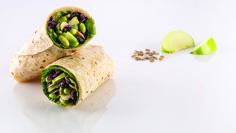 Whole grain wrap filled with romaine, edamame, apples, craisins, toasted almonds, sunflower seeds and poppy seed dressing
