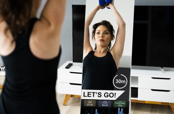 Woman using a smart mirror to workout