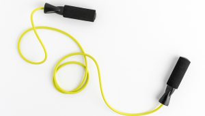 Yellow jump rope with black handles on a white background