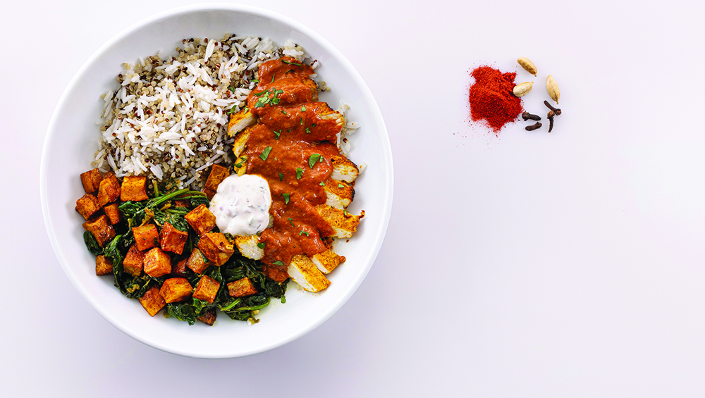 Butter chicken quinoa in a black bowl